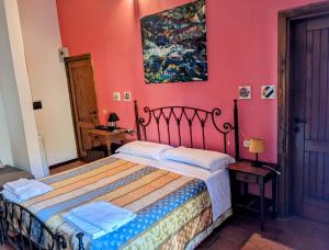 蒙泰蒙阿科拉奇塔代拉迪蒙蒂锡比利尼旅馆的一间卧室配有一张床和粉红色的墙壁