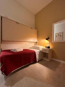 威尼斯Collegio AMDG的一间卧室配有一张带红色毯子的床