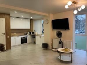 克莱佩达Baltic Avenue的厨房配有壁挂式电视和桌子。