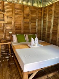 罗哈斯Mecaja Beach House的竹房的一张床位,带毛巾托盘