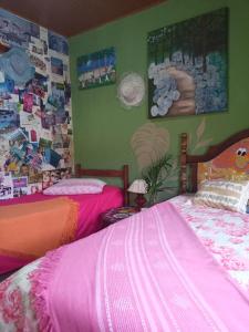 弗洛里亚诺波利斯Casa Hostel Mosaicos DyA的一间卧室设有两张床,墙上挂有图片。