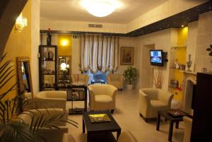曼杜里亚圣保罗酒店 的一间位于沙龙的带椅子和电视的等候室