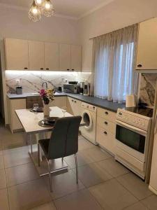 雅典D & A house 150m from Chalandri metro station的厨房配有桌子、炉灶和微波炉。