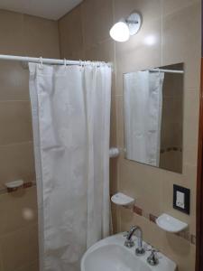 维拉卡洛斯帕兹Departamento San José IV- Villa Carlos Paz的浴室设有白色的淋浴帘和水槽