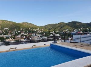 维拉卡洛斯帕兹Departamento San José IV- Villa Carlos Paz的一座山楼屋顶上的游泳池