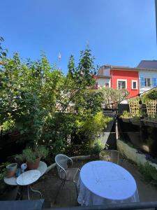 巴黎Full equiped house with garden的庭院设有2张桌子和椅子,树木繁茂。