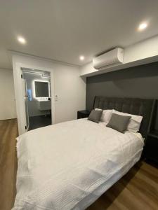 悉尼Luxury inner-west flat w/ breakfast and coffee included!的卧室配有一张带两个枕头的大白色床