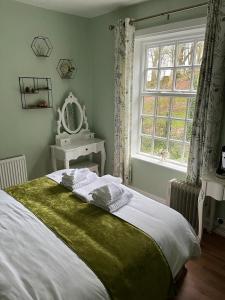 AnnesleyThe Old Postie Bed & Breakfast的一间卧室设有一张大床和一个窗户。