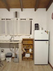 拉帕洛马La Gitana - Casa en La Paloma的厨房配有白色冰箱和水槽