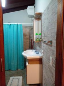 拉帕洛马La Gitana - Casa en La Paloma的浴室设有水槽和蓝色的浴帘
