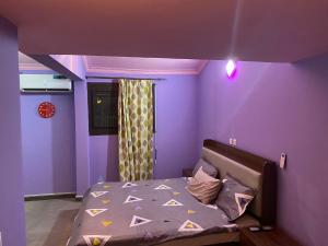 阿比让THE LANDING LODGE-ABIDJAN的紫色卧室,配有一张紫色墙壁床