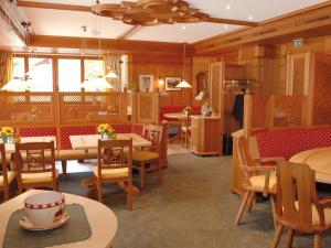 莱赫阿尔贝格弗里茨咖啡厅及膳食公寓的餐厅拥有木墙和桌椅