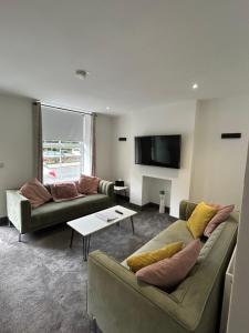 霍姆弗斯Cottage in Holmfirth Centre的客厅配有两张沙发和一台电视机