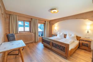 阿尔卑巴赫Haus Forelle的一间卧室配有一张床、一张桌子和一张桌子