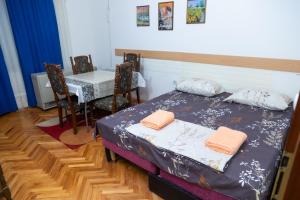 尼什Apartment Bojke的一间卧室配有桌子、床和桌椅
