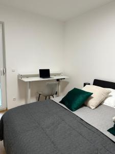 拉斯尼茨霍Harmony Living - 10 min to Graz的一间卧室配有一张床和一张带笔记本电脑的书桌