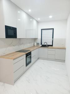 什切青AJP Exclusive House Szczecin的白色的厨房配有木制台面和白色橱柜