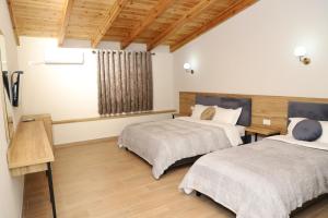 培拉特Mili Hotel的配有木天花板的客房设有两张床。