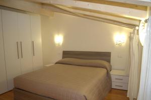 维罗纳Locazione Turistica Aquila的卧室配有一张床,墙上有两盏灯