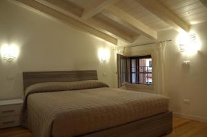 维罗纳Locazione Turistica Aquila的卧室配有一张床,墙上有两盏灯