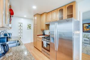 奥克兰Oakland Apartment with Shared Hidden Backyard Oasis!的厨房配有木制橱柜和不锈钢冰箱。
