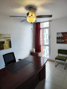 SalsipuedesCute apartment 5min from the airport的配有吊扇的客房内的一张书桌