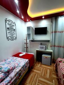 佩尼亚Pousada Cantinho das Flores的小房间设有床铺和电视