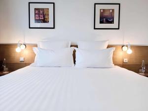 盖朗德城市 & Spa 贝斯特韦斯特酒店的一张白色的大床,配有白色枕头