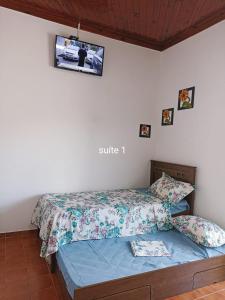 阿帕雷西达Casa para 12 pessoas perto da Basílica e da Feira的卧室配有一张床铺,墙上配有电视