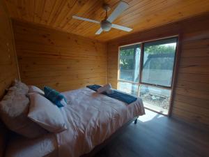 伊丘卡Bushland Cabin near Town, River and Restaurants的一间卧室配有一张带吊扇的床