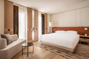 慕尼黑Munich Marriott Hotel City West的卧室配有一张白色的大床和一张沙发。