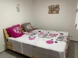 卡佩斯特雷贝勒奥L Oasis des kassaveries的卧室配有一张带白色粉红色床罩的床。