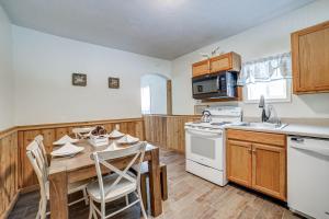 Jones Mills Vacation Rental Near Skiing and Hiking!的厨房配有木桌和白色炉灶烤箱。