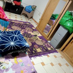 十月六日城بيت الطالبات والمغتربات的一间地板上带地毯和遮阳伞的房间