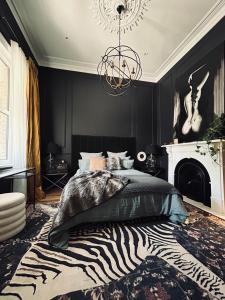 墨尔本The Ritzy Richmond Terrace的一间卧室配有斑马纹床和吊灯。