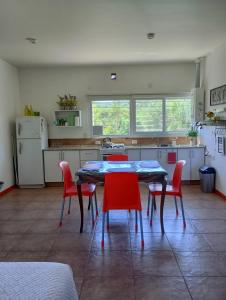 波特雷罗德洛斯弗内斯Loft Las Acacias的厨房配有桌子和红色椅子