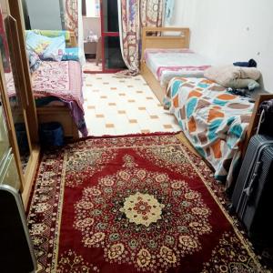 十月六日城بيت الطالبات的一间设有两张床的客房,地板上铺有地毯。