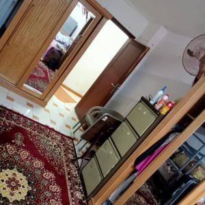 十月六日城بيت الطالبات的厨房配有木制橱柜和镜子