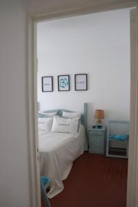 皮纳马尔EDIFICIO CABO FRIO的卧室配有一张床,墙上有三幅照片