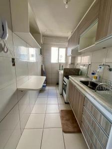 阿拉卡茹Apartamento Clube 3/4 com Ar-condicionado的白色的小厨房,配有水槽和窗户