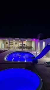 里韦拉Piscina, barbacoa y casa的夜晚在院子里的一个大型蓝色泳池