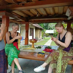 PetangPinge Traditional Village的两个坐在野餐桌旁看手机的女人