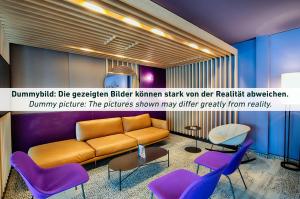 格拉B&B HOTEL Gera的带沙发和紫色椅子的客厅