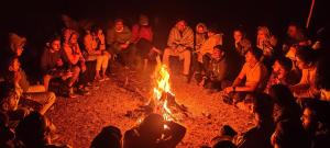 马哈巴莱斯赫瓦尔Yuva Yatri Campsite的一群人围坐在火炉旁