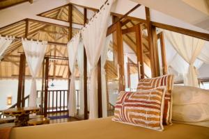 吉利特拉旺安日落海滩别墅酒店的卧室配有带白色蚊帐的床