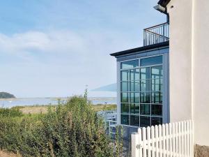 阿森斯Holiday home Assens IV的白色的栅栏和海洋玻璃房子