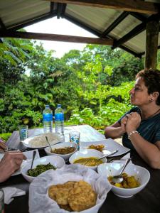 代尼耶耶Rainforest cabin的一群人坐在餐桌旁吃着食物
