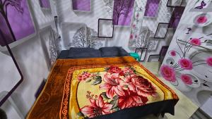 范兰德凡Vrindavan Nivas -Near Prem mandir bankey bihari的一间卧室配有一张带彩色毯子的床