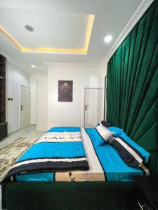 IkuataLuxury Charming 5Bed Duplex With Starlink wifi - Lekki的一间卧室配有一张带绿帘的大床