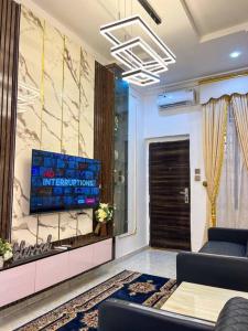 IkuataLuxury Charming 5Bed Duplex With Starlink wifi - Lekki的客厅的墙上配有电视